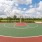 Vibrant outdoor basketball court with lush greenery and a bright blue sky backdrop at Elina in Easton Park