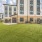 Contemporary apartment building with lush green lawn and fenced seating area in Easton Park