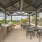 Chic outdoor kitchen area with stainless steel grills and modern dining setup, surrounded by lush greenery and under a stylish pavilion at Elina in Easton Park