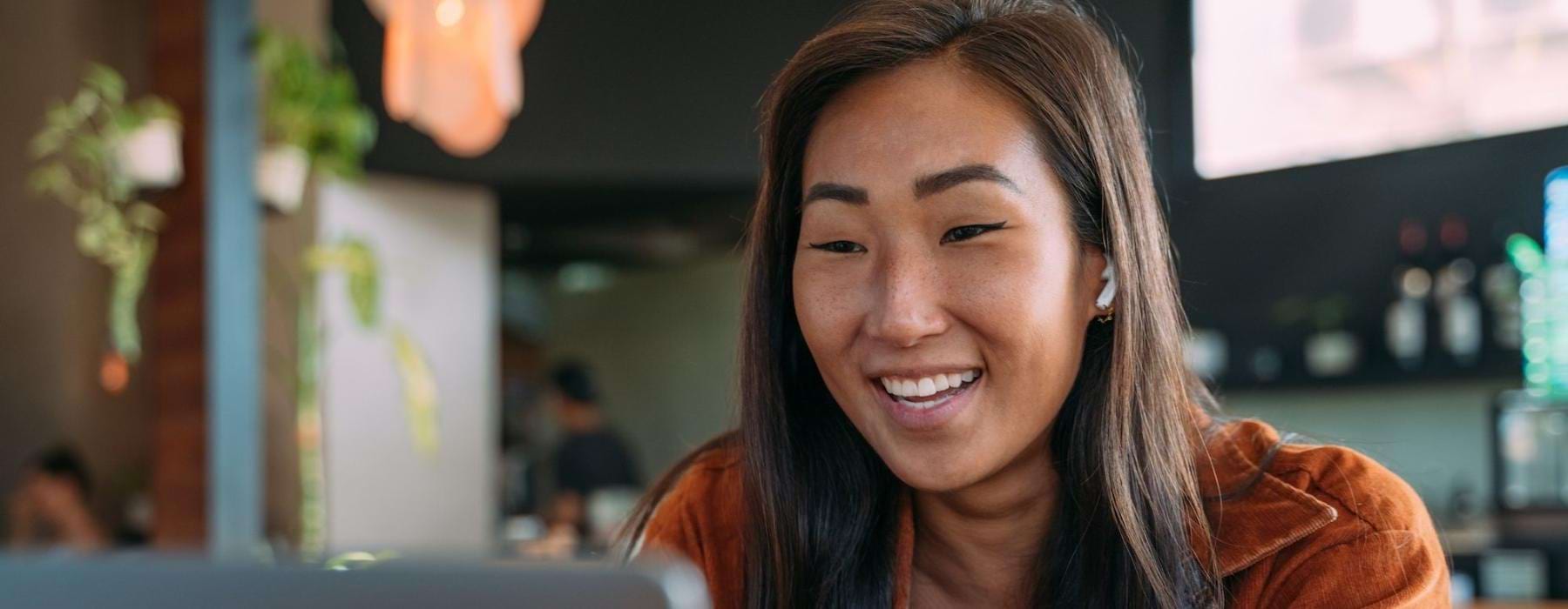 a woman smiling while working on laptop