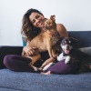 resident sits on the couch with her two dogs