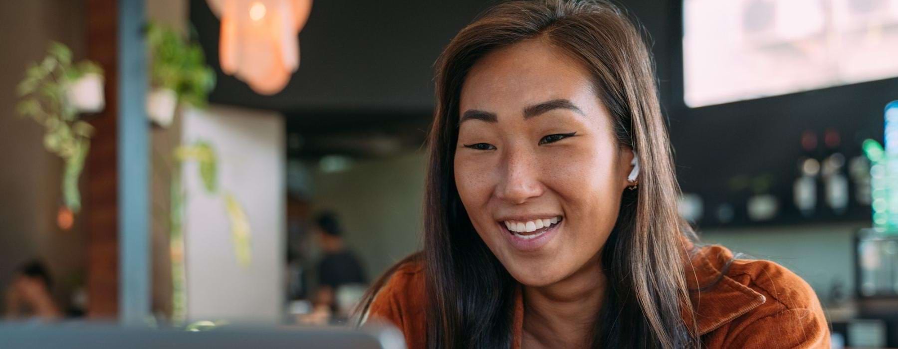 a woman smiling while working on laptop