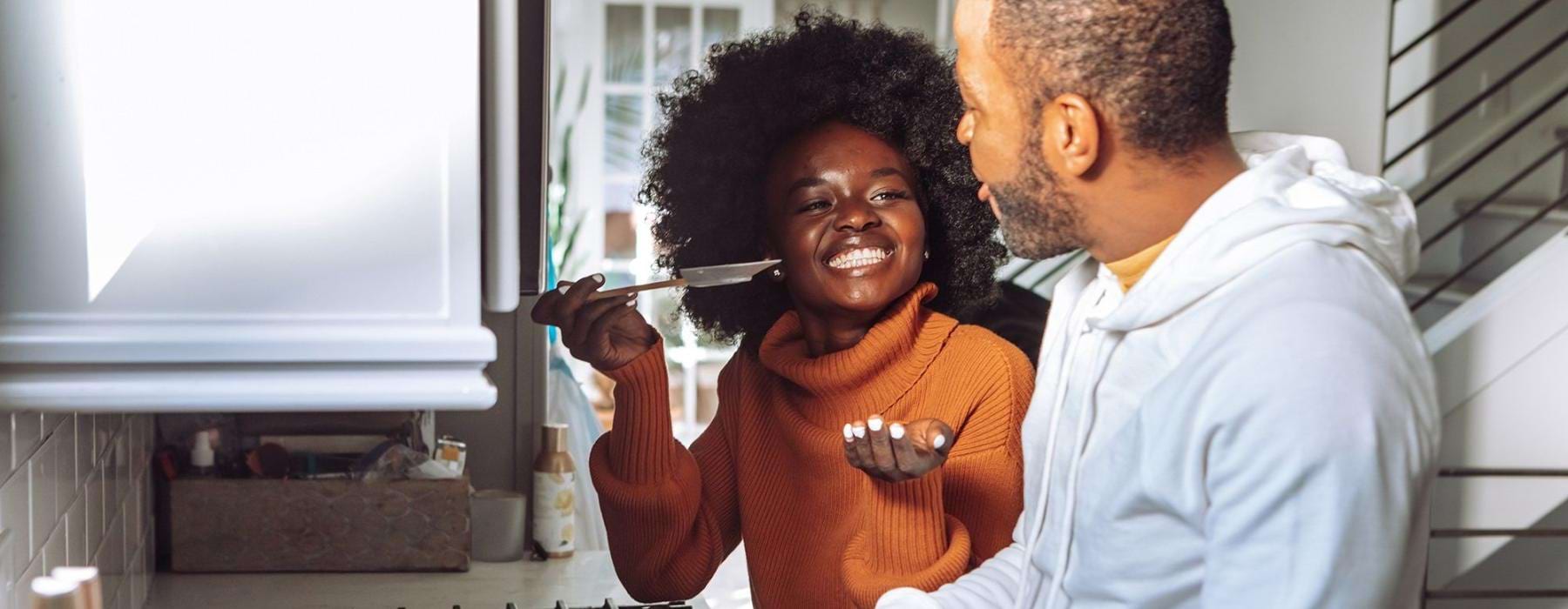 a man and a woman cooking on a gas stove top